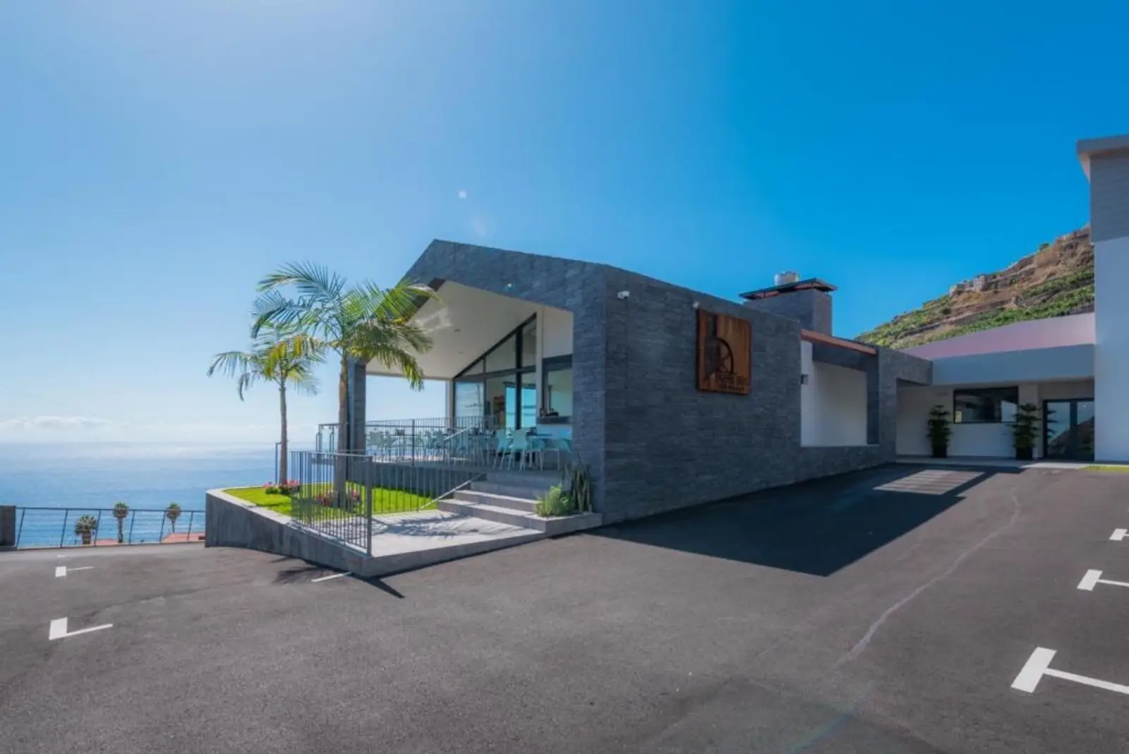 Exterior do Hotel Engenho Velho com palmeiras e vista mar na Madeira